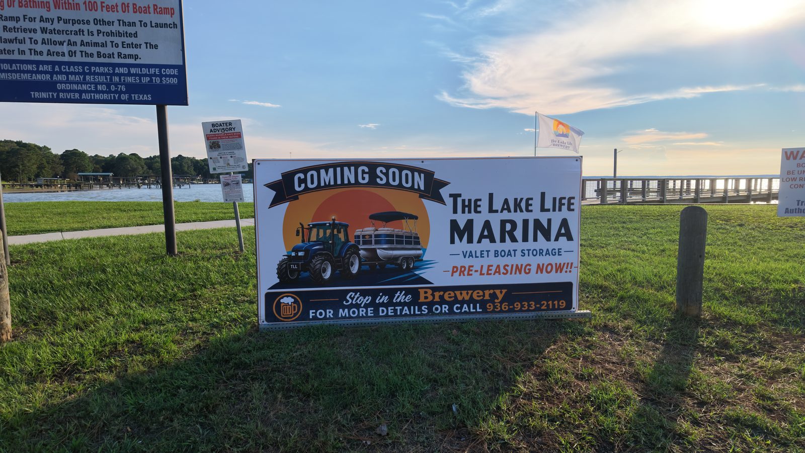 Roadside sign reading The Lake Life Marina, Coming Soon, Valet Boat Storage, Pre-Leasing Now, at the Blanchard boat ramp.