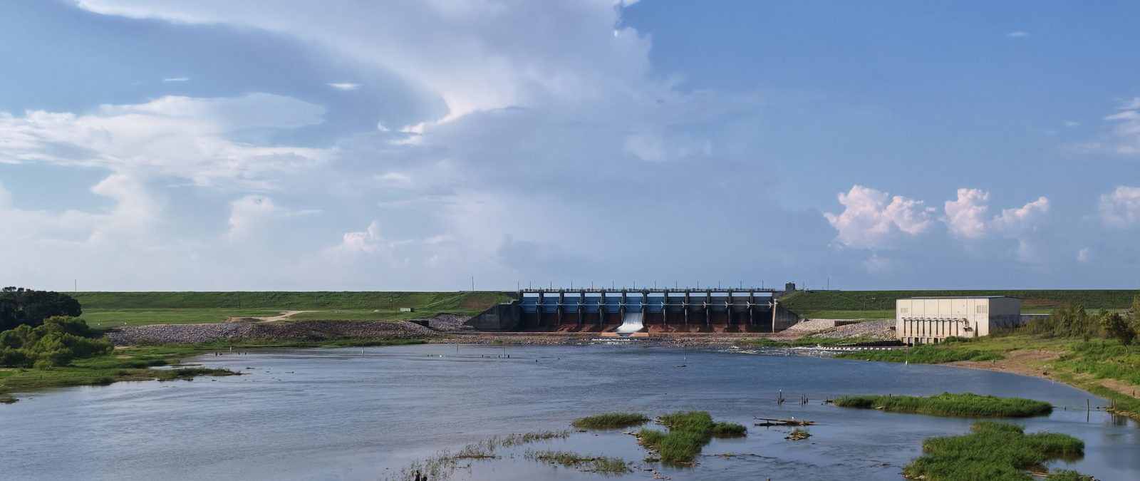 The Lake Livingston Dam spillway seen from downstream, gates open and discharging.